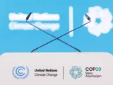 A podium with two crossed microphones, featuring the United Nations Climate Change and COP29 Baku Azerbaijan logos on the front, against a blue background.